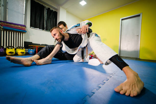 brasilianische jiu jitsu bjj training sparsam zwei athleten in omo plata submission position bohrtechnik tragen kimono gi - ju jitsu stock-fotos und bilder