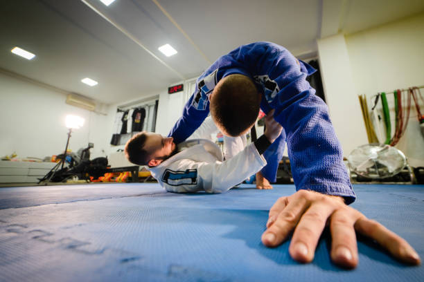 brasilianische jiu jitsu bjj training sparsam zwei athleten in sweep guard position bohrtechnik tragen kimono gi - ju jitsu stock-fotos und bilder