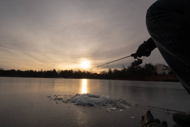 istock Ice fishing during sunrise 1196834097