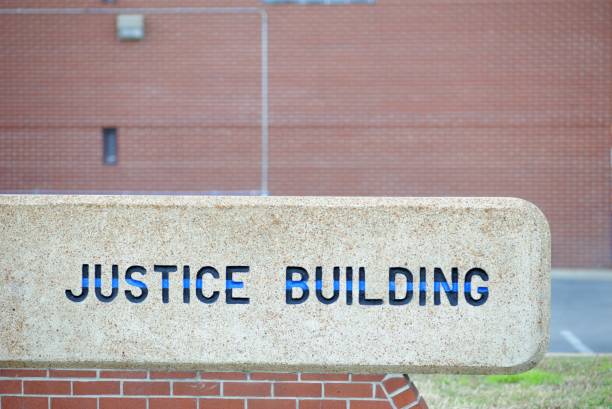 istock Justice building sign with brick wall and copy space 1196834714