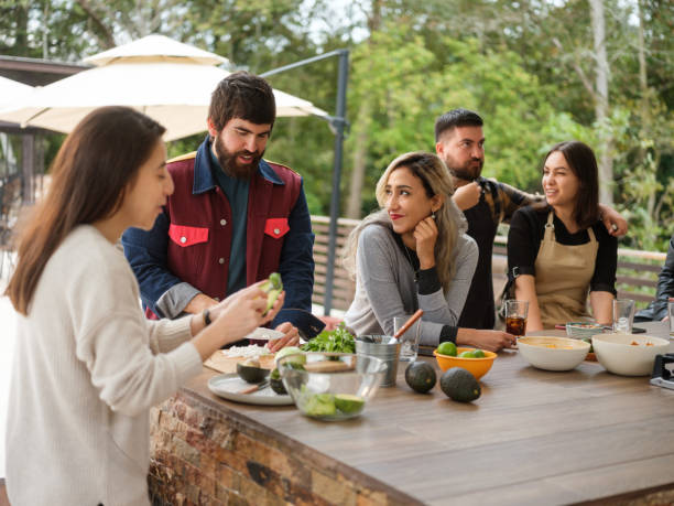 istock Young group of friends having fun and cooking together 1196836657