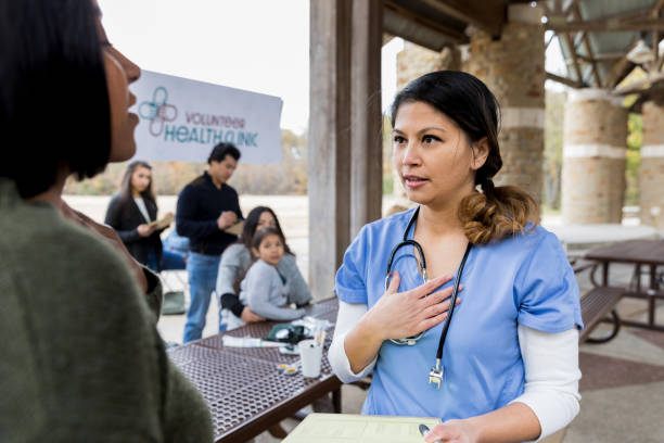 istock Female doctor gestures while talking with patient at free clinic 1196843508