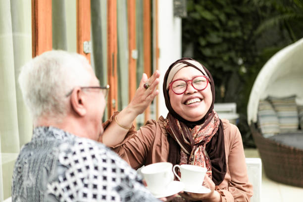 retired couple having teatime relax concept asian elderly couple drinking coffee at home malay couple stock pictures, royalty-free photos & images