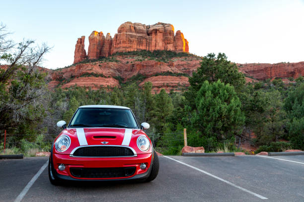 Red Mini Cooper S with white stripes parked in front of Cathedral Rock in Sedona Arizona as the sun is setting over the red rock cliffs with landscape crop SEDONA, ARIZONA / US - August 10, 2019: Red Mini Cooper S with White Racing Stripes Parked in Front of Cathedral Rock in Sedona, Arizona as the Sun is Setting. red rocks state park arizona photos stock pictures, royalty-free photos & images