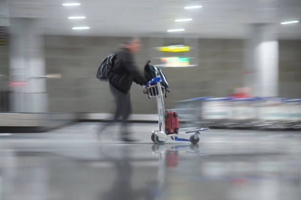 istock Man with trolly collecting luggare at airport 1196850821
