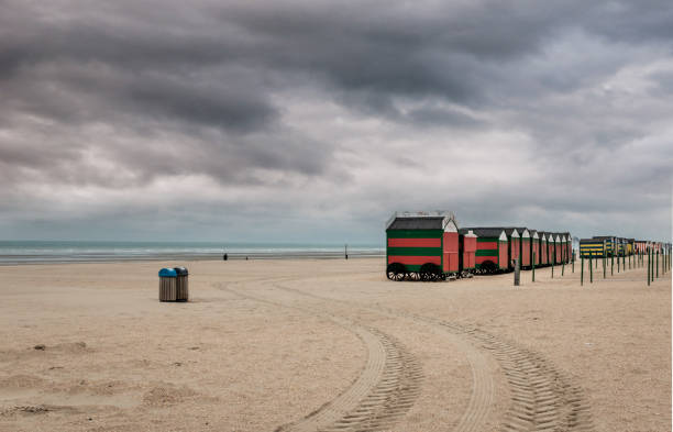 istock Row of colorful beach huts on a cloudy day 1196853221