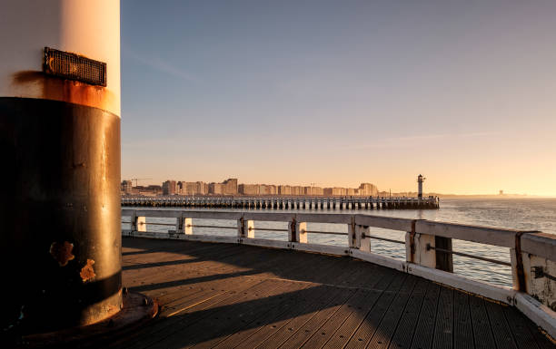 istock Old Nieuwpoort pier and lighthouse at sunset 1196853250