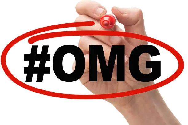 Photo of Hand drawing a red circle around the text #OMG.