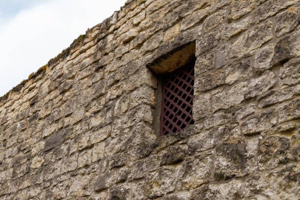 istock Ancient stone wall with small wooden window 1196861251