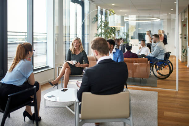 istock Mature Businesswoman Conversing with Young Professionals 1196879657