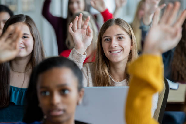 High school students all raise their hands to answer teachers question High school students all raise their hands to answer teachers question teenage high school girl raising hand during class stock pictures, royalty-free photos & images