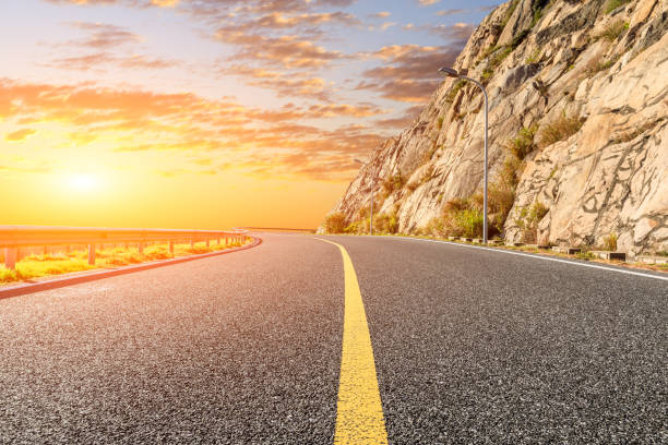 istock Asphalt road and mountains with beautiful colorful clouds at sunset. 1196890665