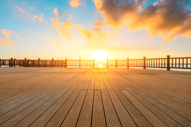istock Lakeside wood floor platform and sky clouds at sunset. 1196890810
