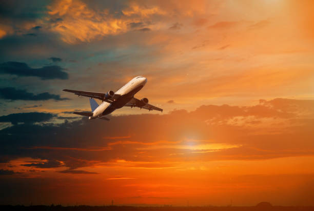 istock Airplane in the sky in dramatic sunset and sunrise sky. 1196907773