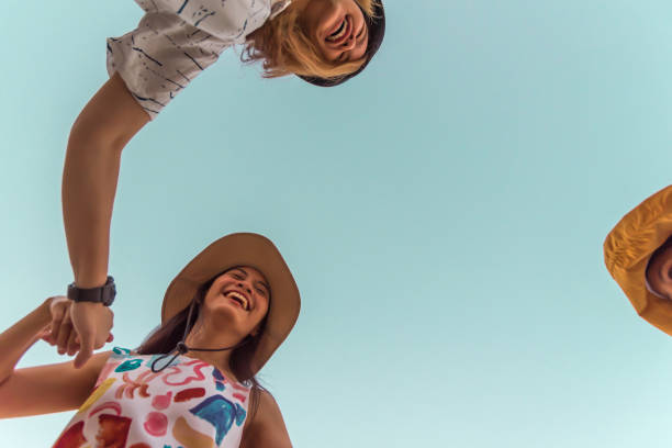 istock Women hold hands circle happy running round camera 1196924127