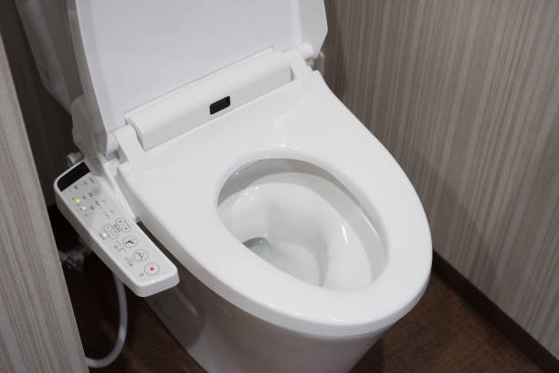 Modern high tech toilet with electronic bidet in Japan. Industry leaders recently agreed on signage standards for Japanese toilet bowls. Modern high tech toilet with electronic bidet in Japan. Industry leaders recently agreed on signage standards for Japanese toilet bowls. japanese toilet stock pictures, royalty-free photos & images