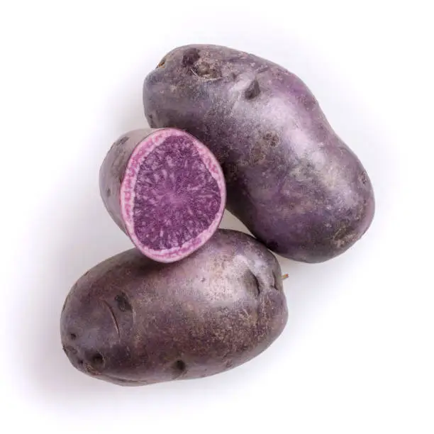 Raw purple potatoes isolated on white background. Top view, close-up.