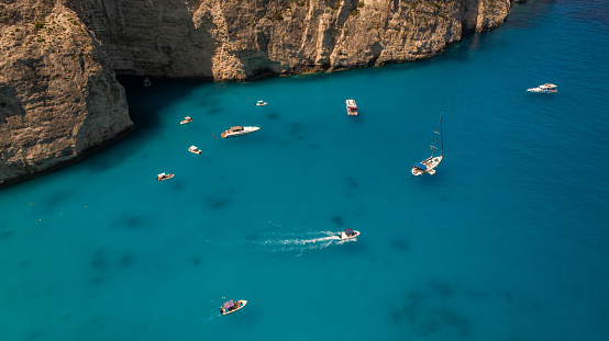 Lot of yachts, boats and sailboats in beautiful bay. This bay is next to the one of the most popular beach on the world, recognizable by turquoise color of water and smuggler's ship that left as wreck. Aerial view photos made with drone. Navagio beach, Zakynthos, Greece