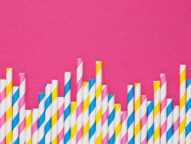 граница бумажных соломинок с полосками на ярко-розовом фоне с копировальной площадью - drinking straw striped isolated nobody стоковые фото и изображения