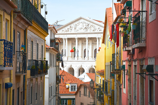 Balconies of old and colorful buildings on Travessa da Arrochela street on a sunny day in summer. Assembly of the Republic building in the background. Travel concept. Lisbon, Portugal. Europe.