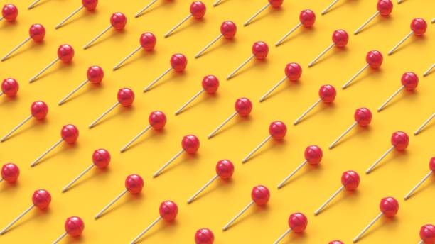 istock Lollipops in rows on yellow background 1196949465