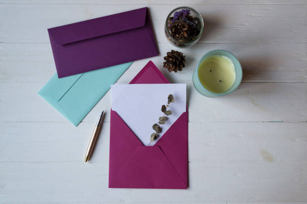 istock The pink envelope with note blank on the white wooden table. Beautiful desktop. Background with place for text. 1196952924