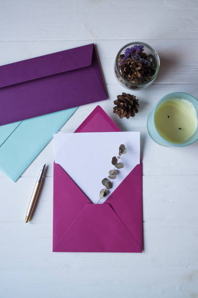 istock The pink envelope with note blank on the white wooden table. Beautiful desktop. Background with place for text. 1196953023