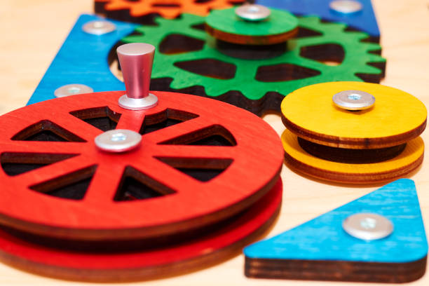 Bright multi-colored wooden gears connected into a complex mechanical system. Children's toy for preschoolers