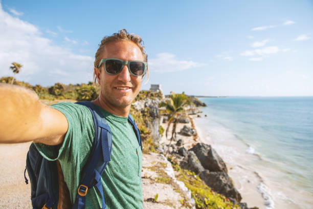 istock Young man taking selfie portrait in Tulum ruins, Mexico 1196960134
