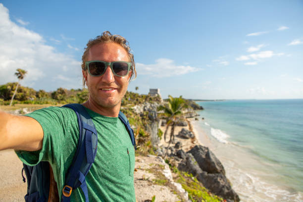 istock Young man taking selfie portrait in Tulum ruins, Mexico 1196960428