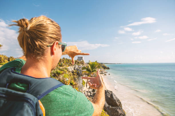 istock Young man framing Tulum ruins with hands Mexico 1196960639