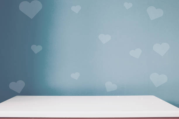 empty white table on the blur dark blue heart wall background