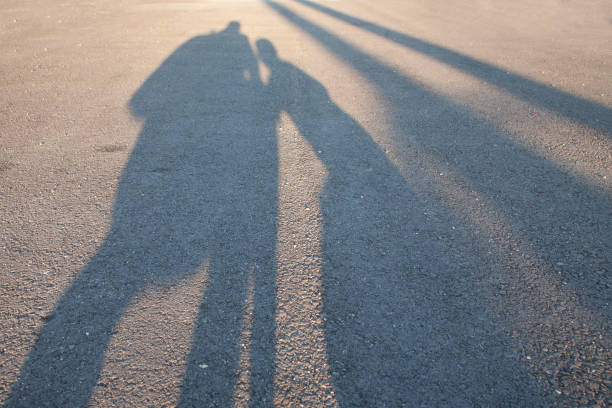 l'ombre du parent et de l'enfant - shadow focus on shadow women sunset photos et images de collection