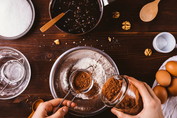 istock Female's hands sift cocoa powder into bowl 1196966397