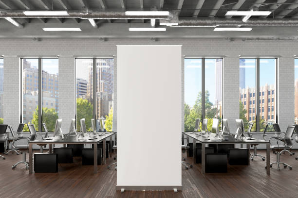 istock Blank roll up banner stand in white brick office interior. 1196966899