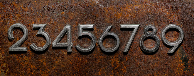 Backgrounds and textures: assorted metal cyrillic digits on a rusty background, typographic art abstract
