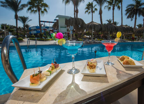 cocktailgetränke auf dem tisch in einem pool des luxus-hotel-resorts - canape buffet cocktail food stock-fotos und bilder