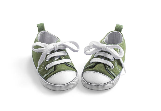 olive baby sneakers on white stock photo