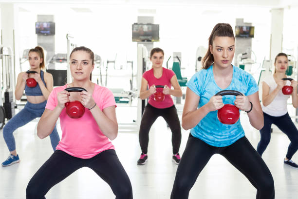 istock Women exercise at gym with kettle bell 1196975352