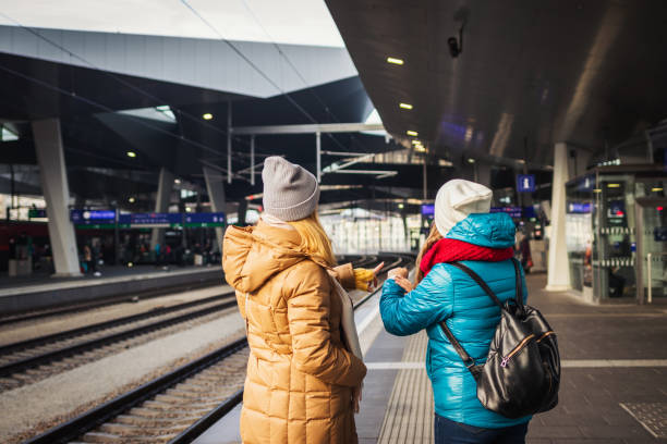 istock Two women waiting for train at railway station and checking time. 1196977272
