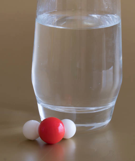 Water illustrated with a hydrogen and oxygen atom which produces a molecular structure. Glass of liquid water and the H2O molecule with one hydrogen and two oxygen atoms . h20 molecule stock pictures, royalty-free photos & images