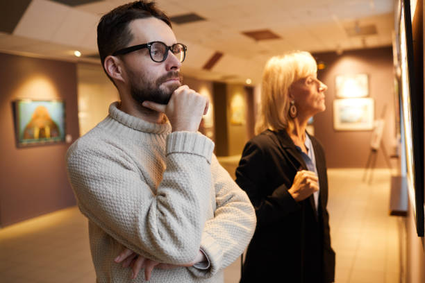 istock Two People Looking at Paintings in Art Gallery 1196980549
