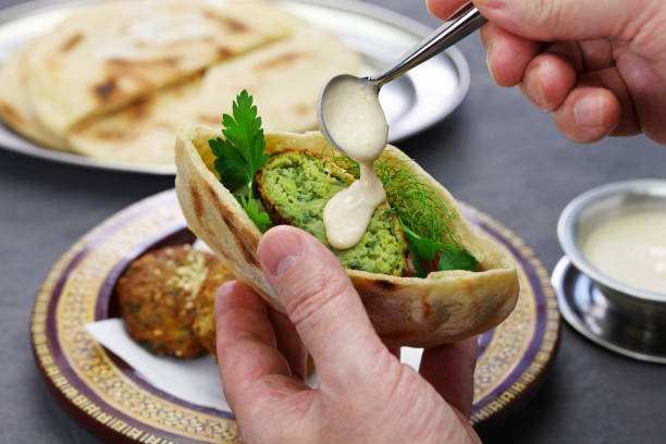 egyptian falafel served in a pita bread with tahini sauce - fava bean bean seed imagens e fotografias de stock