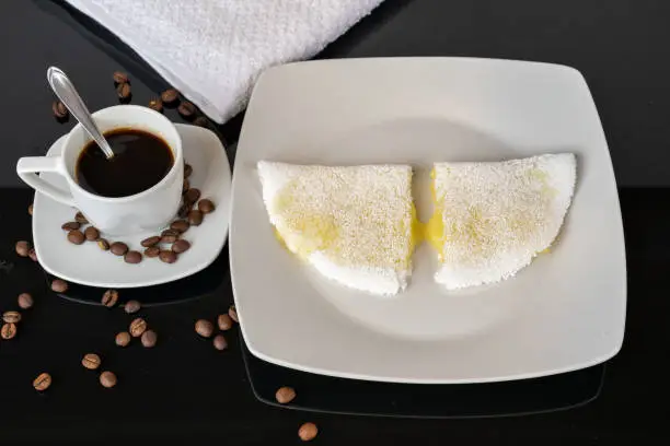Photo of Cheese tapioca with coffee on a mirrored black background (typical Brazilian breakfast, mainly from the Northeast region).