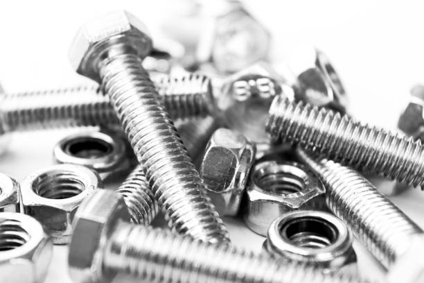 Metal bolts and nuts  in a row background. Chromed screw bolts and nuts isolated. Steel bolts and nuts pattern. Set of Nuts and bolts. Tools for work. Black and white Metal bolts and nuts  in a row background. Chromed screw bolts and nuts isolated. Steel bolts and nuts pattern. Set of Nuts and bolts. Tools for work. Black and white fastening photos stock pictures, royalty-free photos & images
