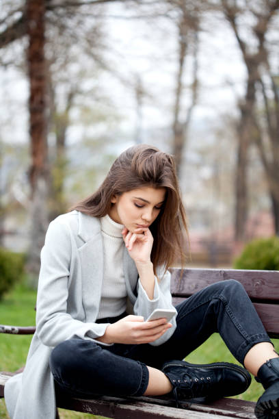 istock young woman with smart phone 1196994032