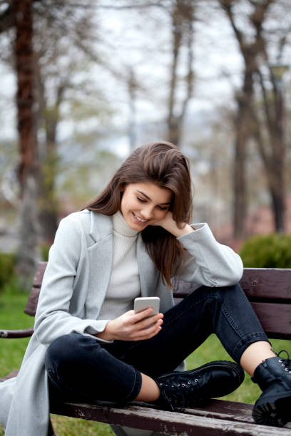 istock young woman with smart phone 1196994090