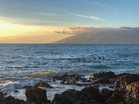 Maui, Hawaii USA 10/01/2018: Coastline along Kihei's Kamaole Beach Park III. The West Maui Mountains can be seen beyond a passing outrigger boat.