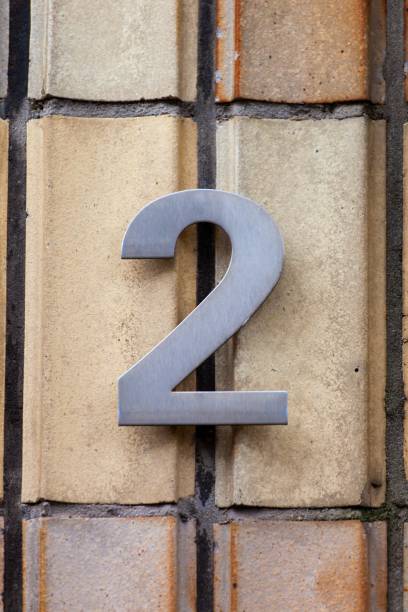istock number 2 metal house number on tile wall 1196999306