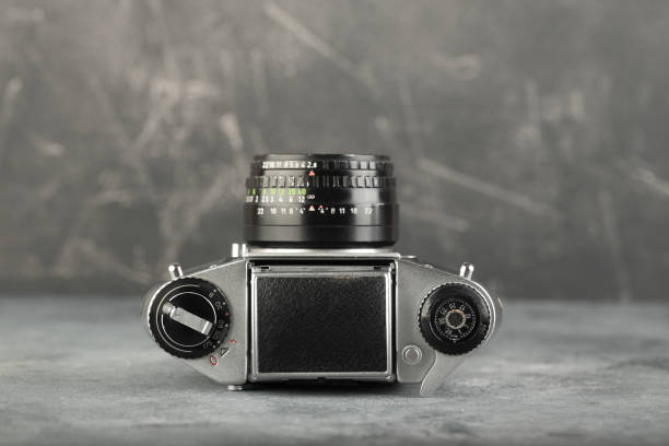 istock The old 35 mm SLR camera with lens on a grey cement background. 1197000361